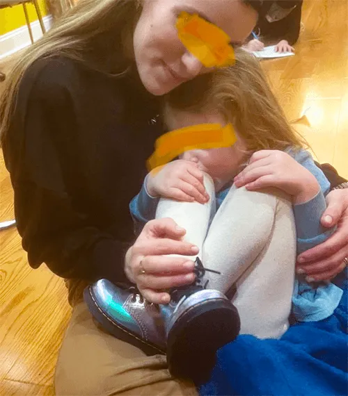 Mom cuddling preschool girl.